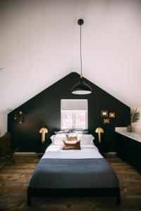 a bedroom with a large bed with a black wall at Noon on Sunset Hill in Los Angeles