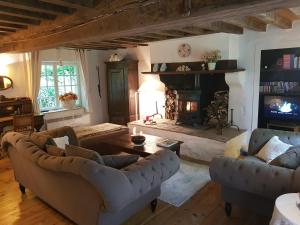 sala de estar con 2 sofás y chimenea en Moulin De Sardeix ( De Cottage ), en Chéniers