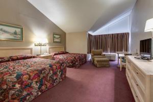 a hotel room with two beds and a television at Green Valley Motel in Pigeon Forge