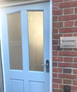 a blue door on a brick building at The Apartment, 24 West End Terrace, Winchester in Winchester