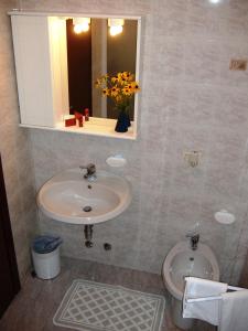 a bathroom with a sink and a toilet and a mirror at Casa Giuly in Villa dʼAlmè