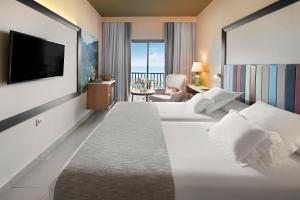 a hotel room with two beds and a flat screen tv at Hotel Gran Rey in Valle Gran Rey