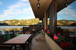 a patio with tables and chairs and a view of the water at Vila Golful Dunării in Dubova