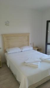 1 cama blanca grande con sábanas y almohadas blancas en ece "vegan"hotel Bodrum, en Golturkbuku