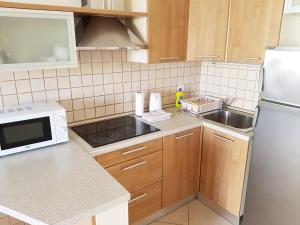 a kitchen with a white refrigerator and a sink at Apartment Jadranka in Novalja