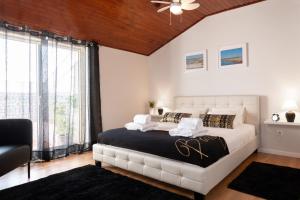 a bedroom with a large bed and a ceiling fan at Feeltheland Ria Residence in Aveiro