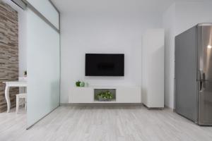 ラスパルマス・デ・グランカナリアにあるSanta Catalina Modern Homeの白いリビングルーム(壁にテレビ付)