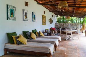 a row of beds in a room with a table at Villa Albergaria in Flecheiras