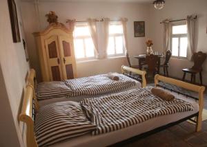 2 camas en una habitación con ventanas en Krumlovské domky en Český Krumlov