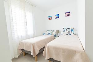 サン・ラファエルにある552 AVENUE DE VALESCUREの白い壁のベッドルーム1室(ベッド2台付)