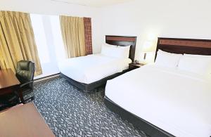 A bed or beds in a room at LELUX Hotel