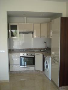 eine Küche mit einem Herd und einem Geschirrspüler in der Unterkunft ESTUDIO EN 1a LINEA in Torremolinos + 17 Fotos