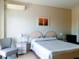 ein Schlafzimmer mit einem Bett und einem Stuhl in der Unterkunft ESTUDIO EN 1a LINEA in Torremolinos