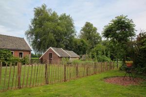 Ein Zaun in einem Hof neben einem Haus in der Unterkunft Gastenhuis de Veenstraal in Gieterveen