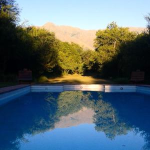 una piscina de agua con árboles y montañas al fondo en Amelie en San Javier