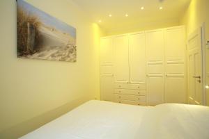 1 dormitorio con 1 cama y una pintura en la pared en Kurpark-Oase en Warnemünde