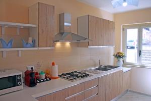 a kitchen with a sink and a stove top oven at BB Aretè in Scilla