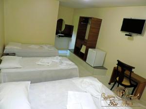 um quarto de hotel com duas camas e uma televisão de ecrã plano em Rio Preto Hotel em Formosa