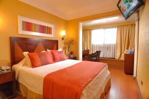 a bedroom with a large bed and a large window at Hotel Gran Palace in Santiago