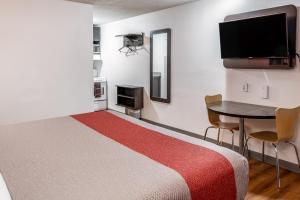 Habitación con cama, mesa y TV. en Motel 6-Fort Nelson, BC en Fort Nelson