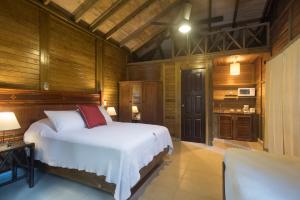 a bedroom with a bed in a room with wooden walls at Hotel Villas El Encanto Cozumel in Cozumel