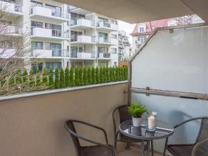 Un balcón con una mesa y sillas y un edificio. en VacationClub - Villa Mistral Apartament 3, en Świnoujście 3 fotos más