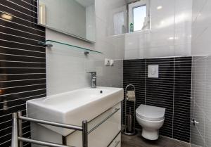 a white bathroom with a sink and a toilet at Apartments Jankovic in Biograd na Moru +8 photos