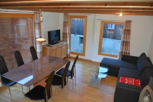 a living room with a table and a couch at Chalet Truffer Ulrichen in Ulrichen