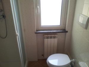 a small bathroom with a toilet and a window at Agriturismo Bell'Aria in Uscio