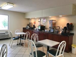 a restaurant with tables and chairs and a counter at Super 8 by Wyndham Ashburn in Ashburn