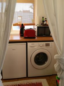 a kitchen with a washing machine and a microwave at La Gola apartaments in Port de Pollensa