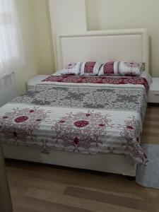 Una cama con un edredón rojo y blanco. en Cerit Pansiyon, en Gokceada Town