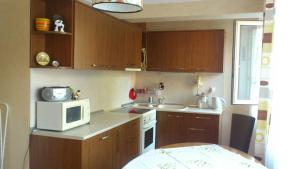 a small kitchen with wooden cabinets and a microwave at Апартамент Граф Игнатиев in Varna City +6 photos