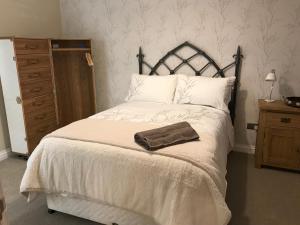 ヨークにあるThrush Nest Cottages - Wren Cottage sleeps 4, 2 bedrooms & Stable Cottage sleeps 2, 1 bedroomのベッドルーム1室(ブラウンタオル付きのベッド1台付)