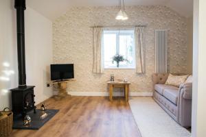 - un salon avec un canapé et une cuisinière dans l'établissement Thrush Nest Cottages - Wren Cottage sleeps 4, 2 bedrooms & Stable Cottage sleeps 2, 1 bedroom, à York