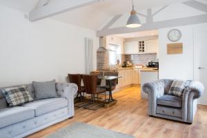 a living room with a couch and chairs and a kitchen at Thrush Nest Cottages - Wren Cottage sleeps 4, 2 bedrooms & Stable Cottage sleeps 2, 1 bedroom in York
