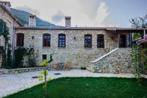 a stone house with a patio and a yard at Mossiori Serai in Sitariá