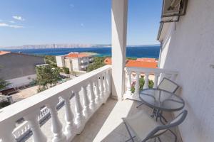a balcony with a table and chairs and the ocean at Stella Maris Accommodation in Klenovica