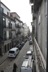 una persona che cammina per una strada con auto parcheggiate di Oporto Almada 329 a Porto