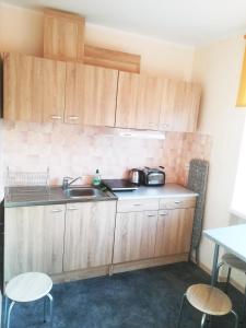 a kitchen with wooden cabinets and a sink and a table at Couple getaway to a freshly renovated apartment in Pärnu