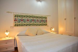 sypialnia z łóżkiem i zasłoną na ścianie w obiekcie Oleandro w mieście Lotzorai