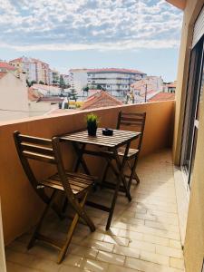 een tafel en stoelen op een balkon met uitzicht bij Gamboa Surf Apartment in Peniche
