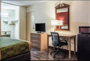 um quarto de hotel com uma cama, uma secretária e uma cadeira em Econo Lodge Fort Payne em Fort Payne