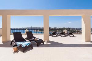 - un ensemble de chaises assises au-dessus d'une terrasse dans l'établissement Sliema Hotel by ST Hotels, à Sliema