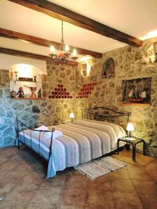 a bedroom with a bed in a stone wall at Apartman Ruza 3 in Poljane