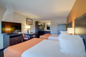 um quarto de hotel com duas camas e uma televisão de ecrã plano em North Platte Inn and Suites em North Platte