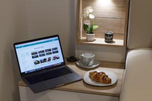 a laptop computer sitting on a desk with a plate of food at Apartments & Rooms Toni in Split