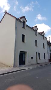 a large white building on the side of a street at CDG Aparts in Le Mesnil-Amelot