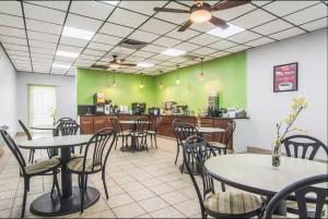 un ristorante con tavoli, sedie e bancone di Econo Lodge Fort Payne a Fort Payne