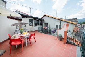 a patio with a table and chairs and an umbrella at Etna Nina's home in Linguaglossa